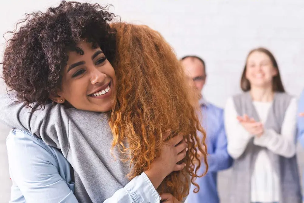 women hugging during therapy session