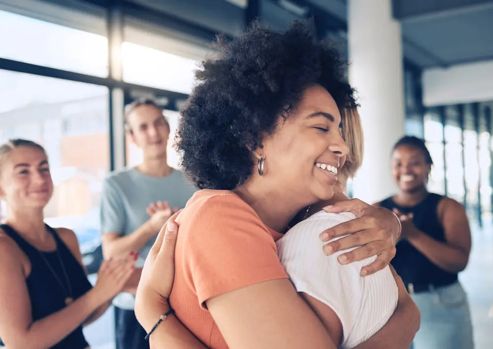 two women hugging in therapy for mental health