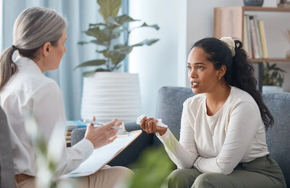 Woman with matching scrunchie speaking with therapist about therapy for stress