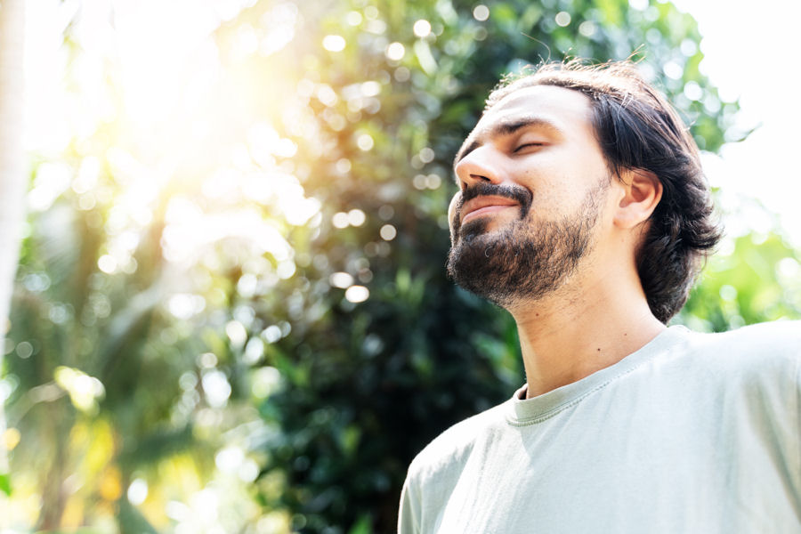 man breathing in fresh air outside while in a holistic php program
