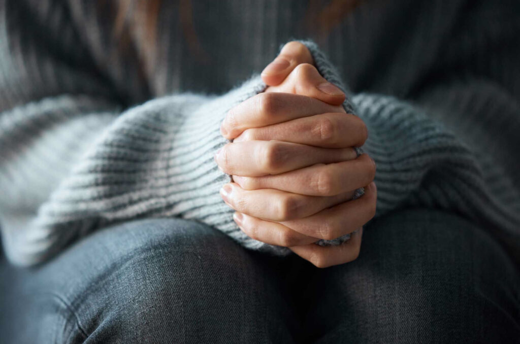 Close shot of woman's hands clasped together