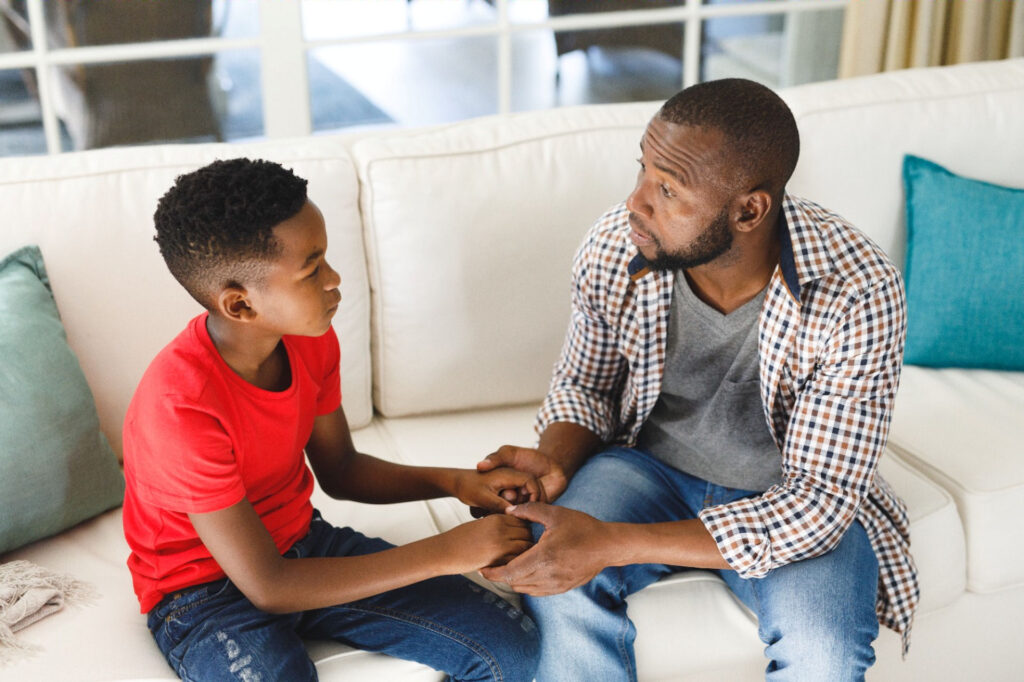 Man holding son's hands and discussing if anxiety runs in families